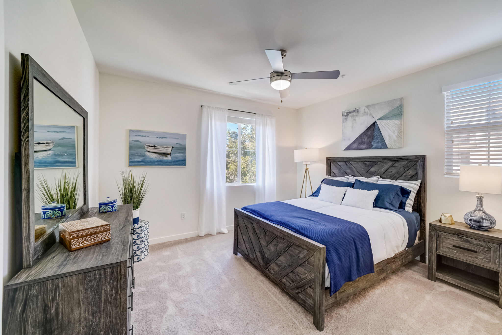 Modern bedroom with a large bed and ceiling fan, providing a relaxing atmosphere at Vistara Apartments.